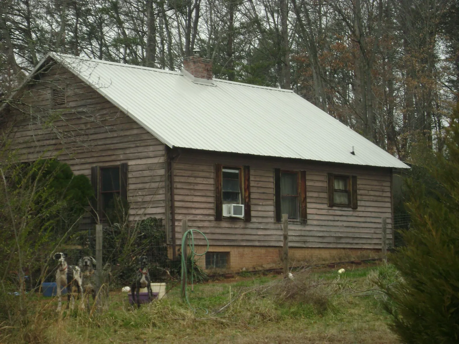White metal roof on an old wood sided farmhouse, from a Metal Roof Installation job in Lake Forest